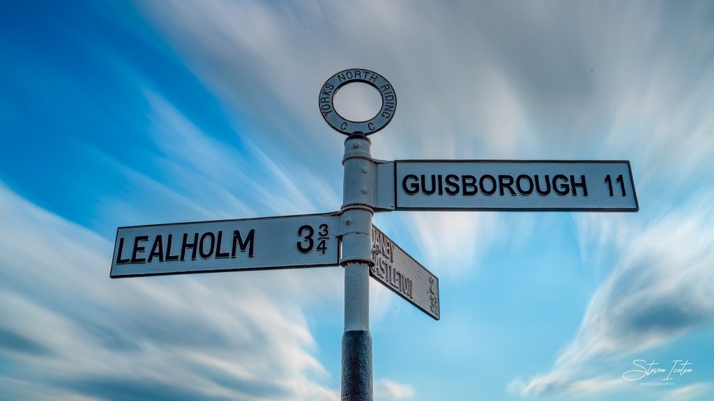  A long exposure photograph of the clouds moving over the old signposts at Danby.